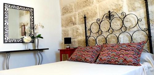 a bed with a red pillow and a mirror at Casa Trini in La Mareta