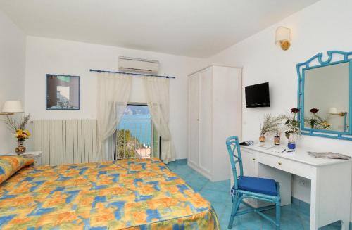 アマルフィにあるヴィラ マリア ルイジアのベッドルーム(ベッド1台、デスク、鏡付)