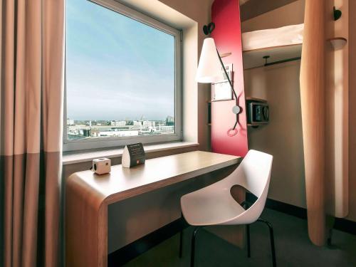a room with a desk with a chair and a window at ibis Amsterdam City West in Amsterdam