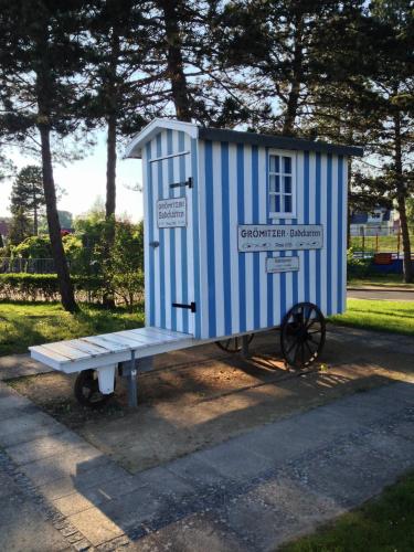 a smallshed sitting on a bench in a park at Strandhus - Haus 37 in Grömitz