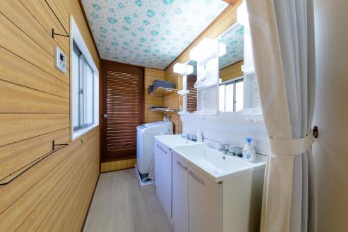 une salle de bain avec un lavabo et des toilettes et une fenêtre dans l'établissement Villa RAKUWA Bettei, à Fujikawaguchiko