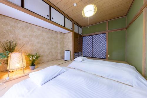 a bedroom with two beds and a chair at Villa RAKUWA Bettei in Fujikawaguchiko