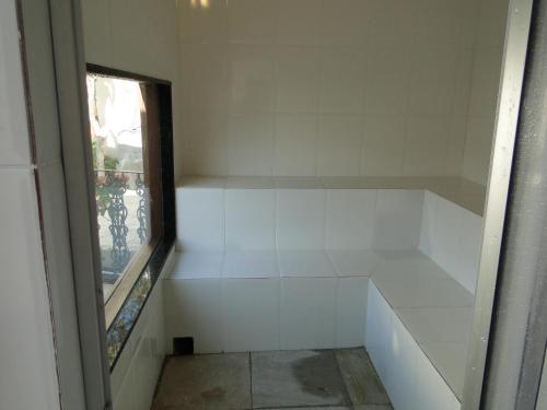 a room with white walls and a window at Pousada Doce Paraty in Paraty