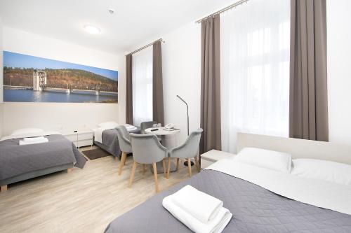 a bedroom with two beds and a table with chairs at Hotel Stronie in Stronie Śląskie