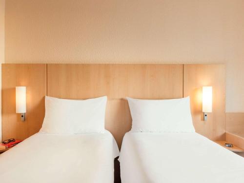 two beds sitting next to each other in a room at ibis Paris la Défense Esplanade in Courbevoie