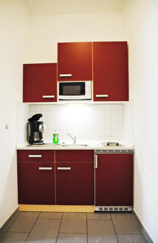 a kitchen with brown cabinets and a microwave at Appartementanlage-Ferienwohnungen Weiße Möwe in Sassnitz