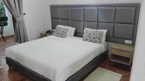 a bedroom with a large bed with a large headboard at Hôtel Mandy in Tetouan