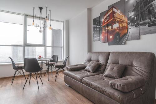 a living room with a brown couch and a table at In the sky apartment Kyiv in Kyiv