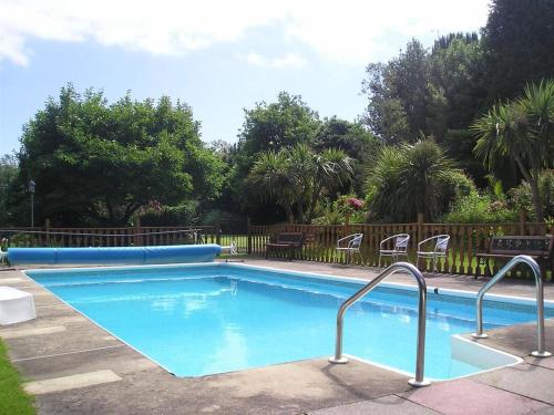 a large blue swimming pool with chairs around it at The Elmington Hotel in Torquay