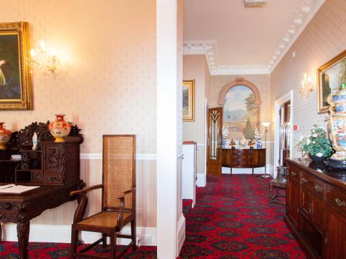 a hallway with a table and chairs in a room at Elmington Hotel in Torquay