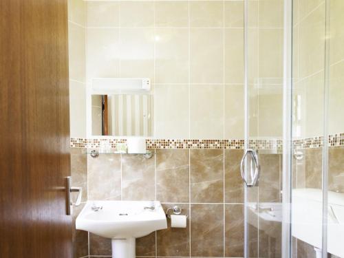 La salle de bains est pourvue d'un lavabo et d'une douche. dans l'établissement Elmington House- Adults Only, à Torquay