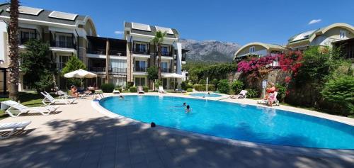 a swimming pool in a resort with people in it at Sultan Homes Apartments 2 in Kemer