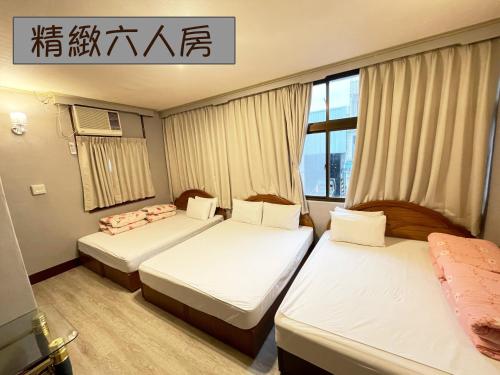 a hotel room with two beds and a window at Yi Mei Hotel in Jinshan