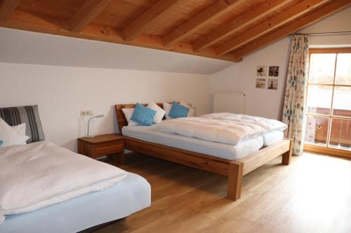 a bedroom with two beds and a window at Ferienwohnung Pferdehof Pankratz in Iffeldorf