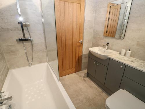 a bathroom with a tub and a toilet and a sink at The Hay Barn in Houghton le Spring