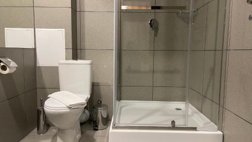 a bathroom with a toilet and a glass shower at Готельно-рестораний комплекс Silver in Ivano-Frankivsʼk