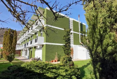 a green and white building with a yard at Hotel del Trueno in Ezcaray