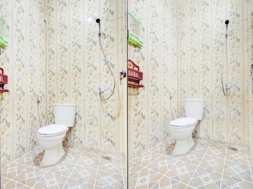 a bathroom with two toilets and a shower at OYO Life 90152 Garuda Bima Residence Syariah in Tangerang