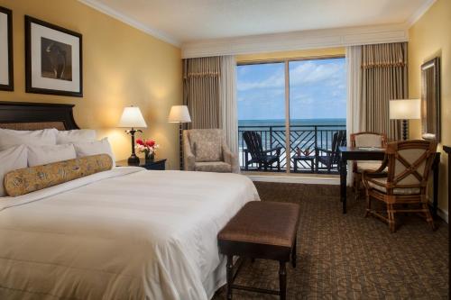 um quarto de hotel com uma cama grande e uma varanda em Sandpearl Resort Private Beach em Clearwater Beach