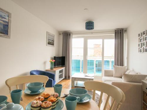 a living room with a table with food on it at Nautical Breeze in Weymouth