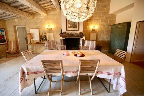une salle à manger avec une table, des chaises et un lustre dans l'établissement Maison charmante à Marsillargues, à Marsillargues
