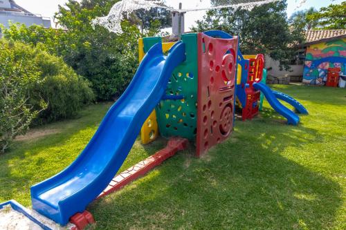 a playground with a slide in a yard at Hotel Porto Sol Beach in Florianópolis