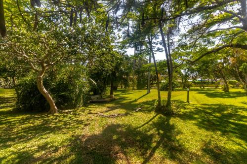 a park with trees and a bench in the grass at Hotel Porto Sol Beach in Florianópolis