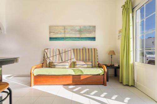 um sofá numa sala de estar com uma janela em El Sombrerito 1 em Caleta de Sebo