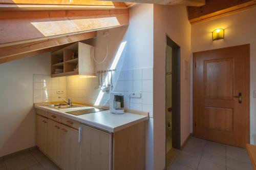 a small kitchen with a sink and a door at Hotel garni Sterff in Seeshaupt