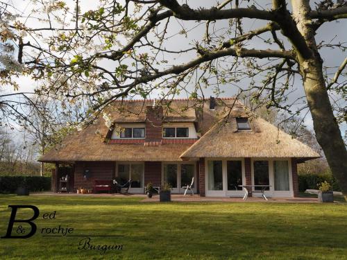 a large house with a thatch roof at Bed & Brochje Burgum in Bergum