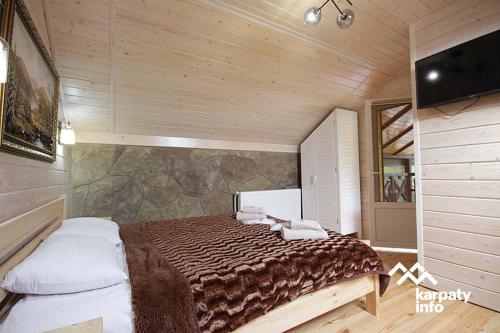 Un dormitorio con una cama en una habitación de madera. en Hammam Spa Villa DAROSO, en Kosiv