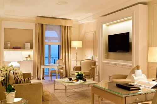 a living room filled with furniture and a tv at Beau-Rivage Palace in Lausanne