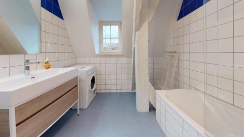 a bathroom with a sink and a washing machine at COLMARAPPART Grand'Rue in Colmar