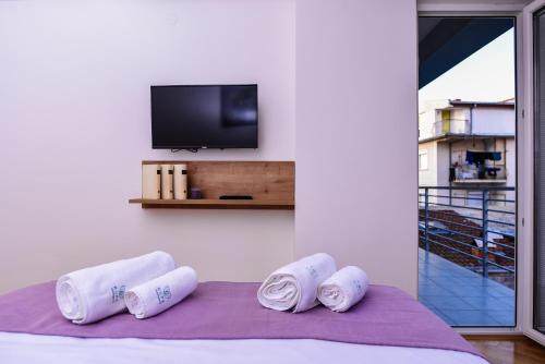een kamer met een bed, een tv en handdoeken bij RUPE Apartments - FREE PARKING in city center! in Ohrid