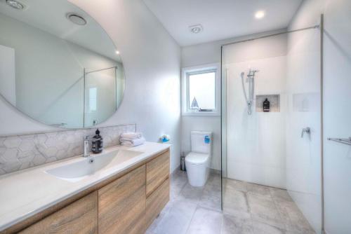 W łazience znajduje się umywalka, toaleta i lustro. w obiekcie Archella 2 w mieście Coles Bay