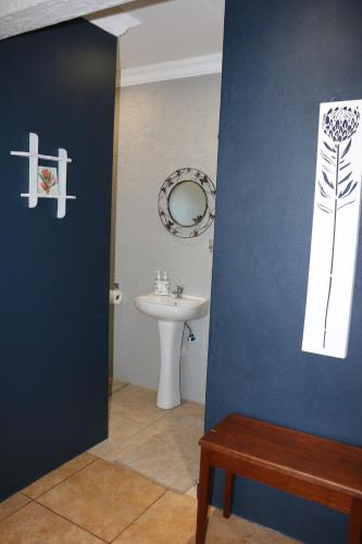 a bathroom with a sink and a toilet and a mirror at White Linen Guesthouse in Tierpoort