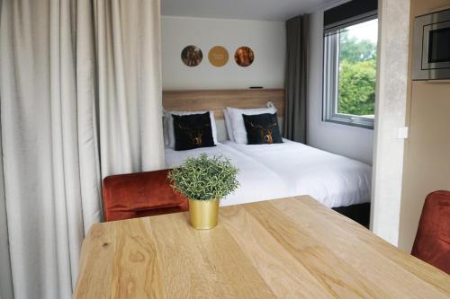 ein Hotelzimmer mit einem Tisch und einem Bett in der Unterkunft 2-persoons Hotellodge in Voorthuizen