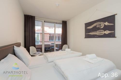 ein Hotelzimmer mit 2 Betten und einem Tisch in der Unterkunft 3-persoons comfort appartement in Zoutelande