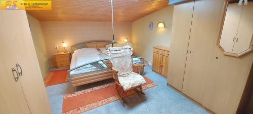 ein Schlafzimmer mit einem Bett und einem Stuhl in einem Zimmer in der Unterkunft Apartment Sandra by FiS - Fun in Styria in Tauplitz