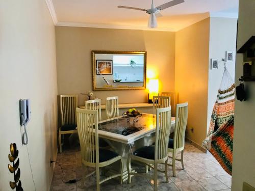 a dining room with a table and chairs at Lindo apartamento 200 metros da praia! in Ubatuba