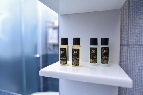 drie flessen odorizers op een plank in een badkamer bij RUPE Apartments - FREE PARKING in city center! in Ohrid