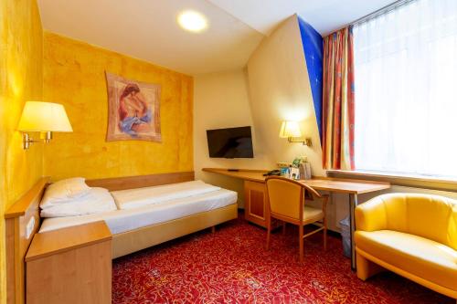 a hotel room with a bed and a desk at ALLVITALIS Traumhotel in Karlsruhe