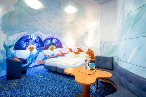 a bedroom with a bed and a table in a room at ALLVITALIS Traumhotel in Karlsruhe