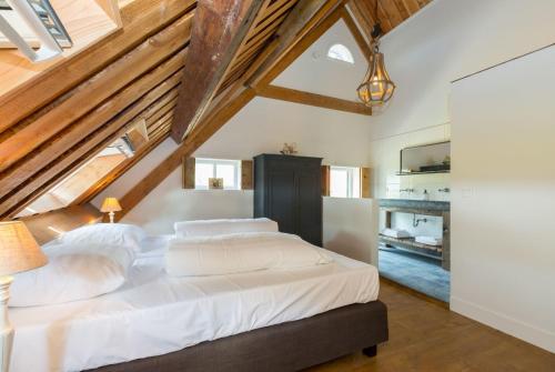 1 dormitorio con 1 cama blanca grande y techos de madera en Holidayhouse - Lepelstraat 18AB Vrouwenpolder, en Vrouwenpolder