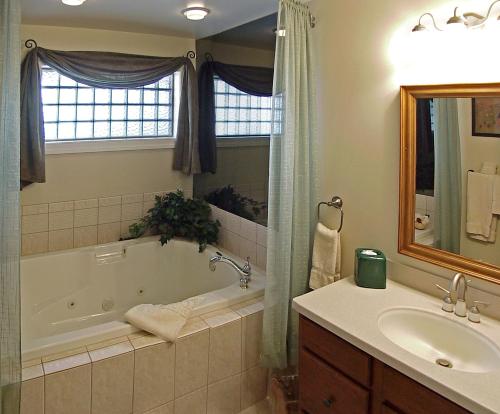 La salle de bains est pourvue d'une baignoire et d'un lavabo. dans l'établissement Bird-in-Hand Village Inn & Suites, à Bird-in-Hand