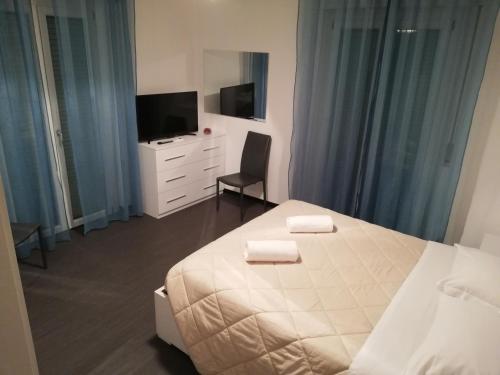 a bedroom with a white bed and a television at Albergo Roma in Lanciano