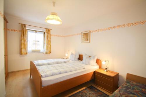 1 dormitorio con cama y ventana en Ferienwohnung Jodlhof, en Obing