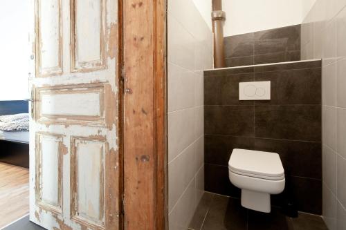 an old door in a bathroom with a toilet at Zentrales & modernes City-Apartment in Graz