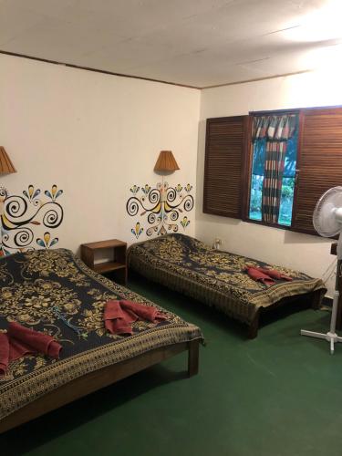 a hotel room with two beds and a window at El Pargo Feliz in Montezuma