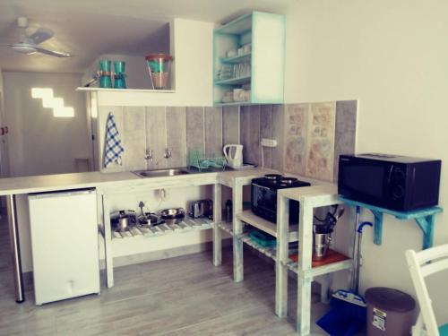 a kitchen with a counter with a sink and a stove at Sandy Feet Self Catering Accommodation in Pearly Beach